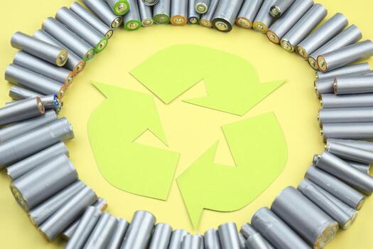 A lot of Used AA batteries and proper disposal of environmentally and soil toxic batteries on the green background. photo