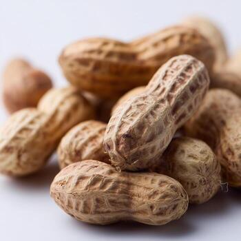 A close-up view of unshelled peanuts displaying their textured, tan shells with characteristic ridges and irregular shapes photo
