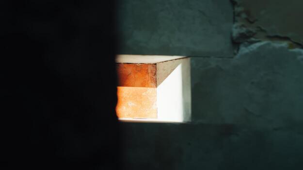 Lighting effect seen through a wall opening in a rustic setting photo