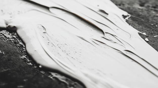 Fluid texture of white paint on a dark surface photo