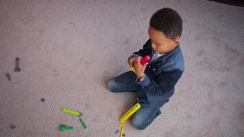 African American child building playing with toys kid on floor in house home boy son play cognitive development repair game enjoying leisure time with construction plastic toy in family apartment video