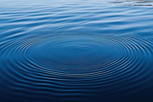 Ripples spreading across calm water at dawn photo