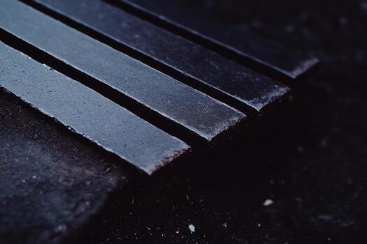 Dark metal bars lined up on a textured surface photo