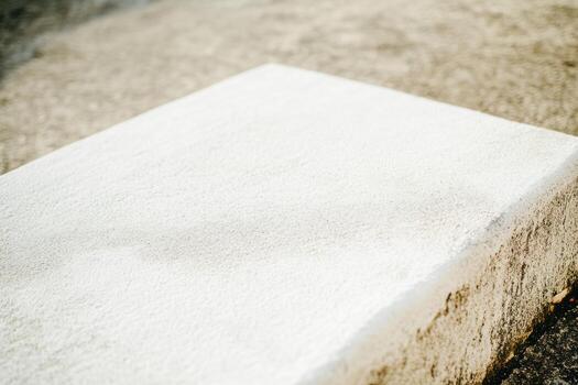 White concrete slab positioned on rough ground surface photo