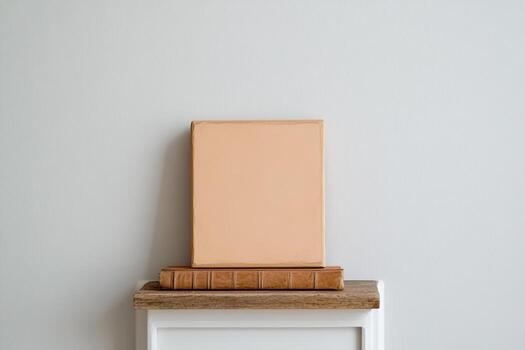 Empty canvas on wooden shelf above vintage books photo