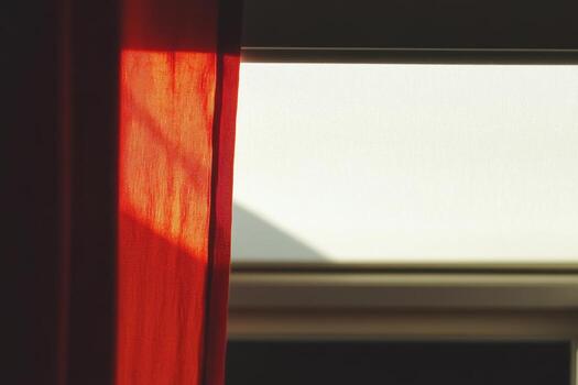 Soft light filtering through a red curtain in a quiet room photo
