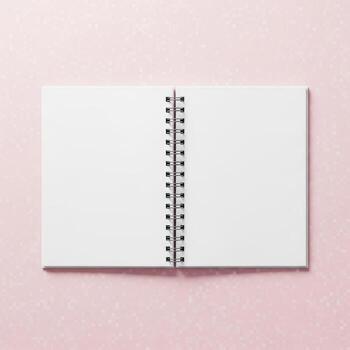 An open spiral bound notebook with blank white pages presented isolated on white background photo