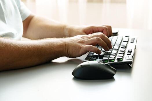 Person typing on a keyboard with a mouse beside on a minimal workspace desk photo