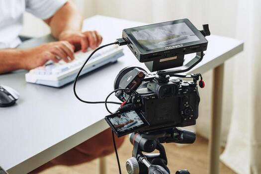 Filming a tutorial at a modern workspace with advanced camera setup and keyboard use photo