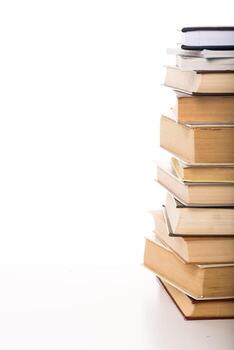 Stacked books in various sizes and colors on a plain background showcase knowledge and stories photo