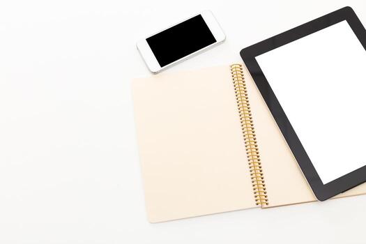 Notebook and digital devices arranged on a blank surface for study or work tasks photo