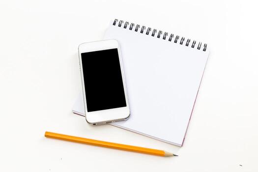 Notebook and smartphone arranged on a desk for creative brainstorming session photo