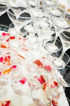 Glasses stacked in an intricate display with colorful ice cubes at an elegant event photo
