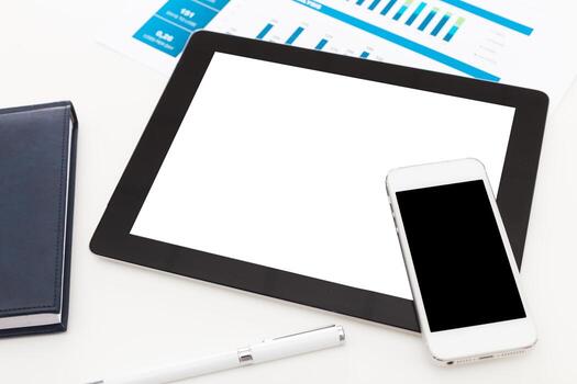 Workspace setup with tablet, smartphone, and documents showcasing data analysis photo