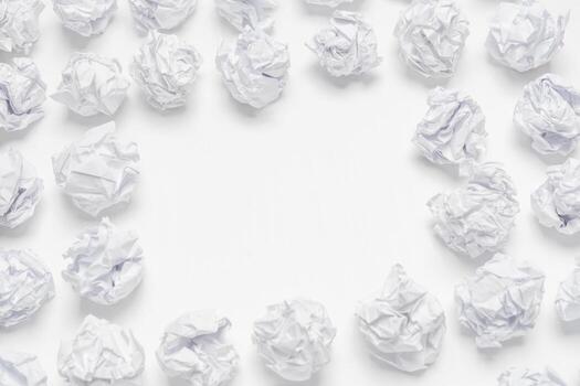 Crumpled white paper forming a circular pattern on a plain background in a creative workspace photo