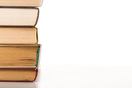 Stack of old books resting on a white surface with visible spine details and textures photo