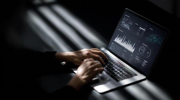 Working on data analysis with a laptop in low light environment during nighttime hours photo