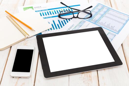 Work desk setup with tablet, smartphone, and documents during a budgeting session photo
