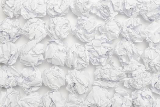 Crumpled white paper creating an abstract pattern across a flat surface photo