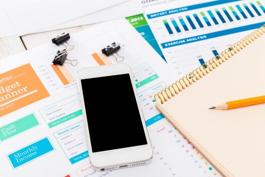 Budget planning and financial analysis using mobile device and documents on workspace photo