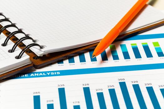 Data analysis in progress with graphs and a notepad lying on a table photo