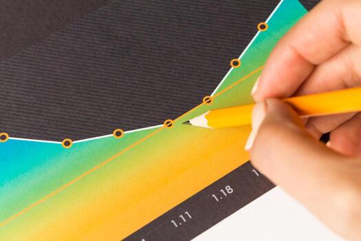Analyzing data trends with a colored pencil on a graph during a study session photo