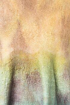 Textured fabric displaying gradient colors of earth tones in a close-up view photo