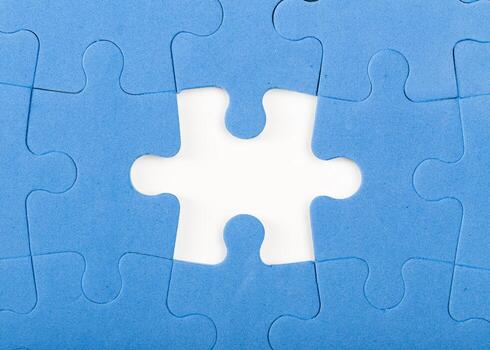 Missing piece in a blue puzzle on flat surface with empty space showing photo