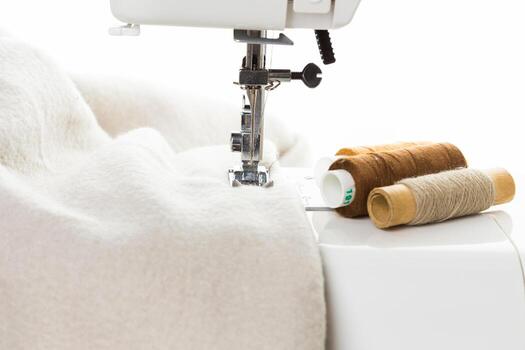 Crafting a fabric project with a sewing machine and spools of thread in a bright workspace photo