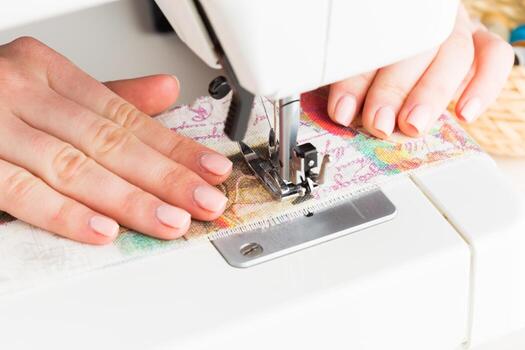 Hands crafting a colorful fabric project using a sewing machine in a well-lit workspace photo