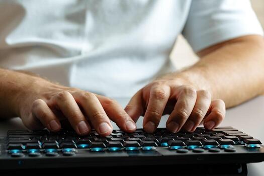 Man typing on keyboard in well-lit home office setting during daytime photo