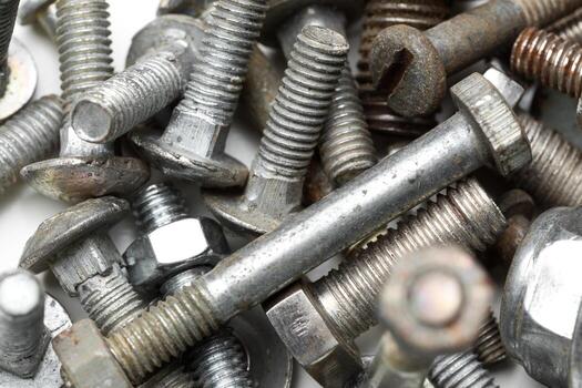 Assorted bolts and nuts scattered on a surface in a workshop photo
