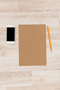 Workspace setup with blank paper, smartphone, and pencil in minimalistic setting photo