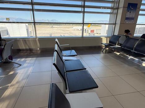 Empty waiting area in airport terminal with view of runway. Travel, observation, and waiting moments in passenger transportation spaces. photo