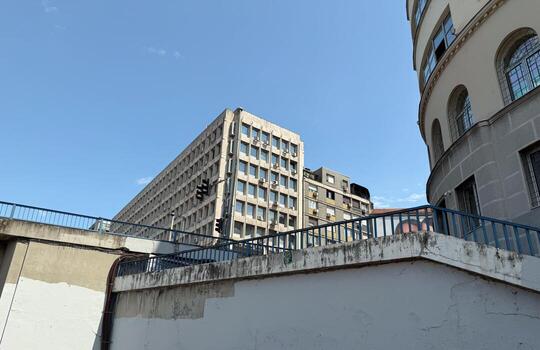 Modernist building facade in Belgrade with rectangular grid of windows and concrete structure under clear sky. Urban architecture, heritage, functionalism, identity photo