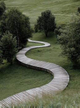 A wooden path that is curved around a green field photo