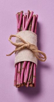A bundle of twine wrapped around a stick of pink wood photo