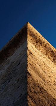 A plane flying over a building with a blue sky photo