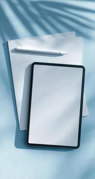 Tablet and pen on blue background with palm tree photo