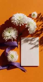 White flowers and a blank card on an orange background photo