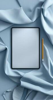 Tablet with blank screen and pen on blue fabric background photo