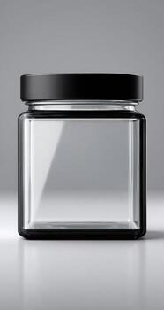 Empty glass jar with black lid on a gray background photo