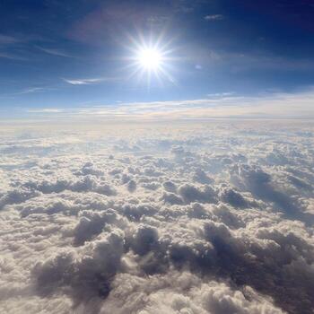 The sun shines over the clouds in this photo