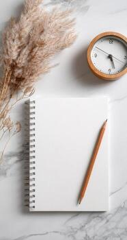 Blank notebook, pen, clock, and dry reeds on white marble background photo