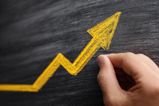 Hand drawing a growing arrow on a blackboard photo