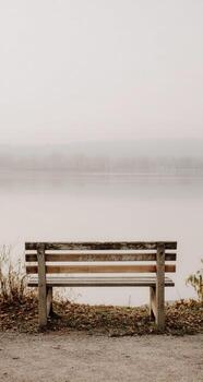un banco sentado por un lago foto