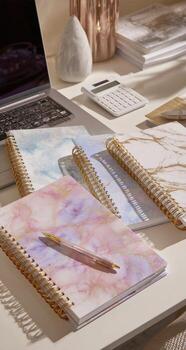 A notebook, pen and laptop on a desk photo