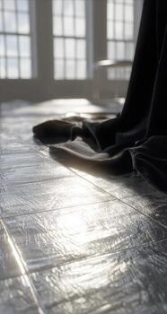 A black cloth is laying on the floor in front of a window photo