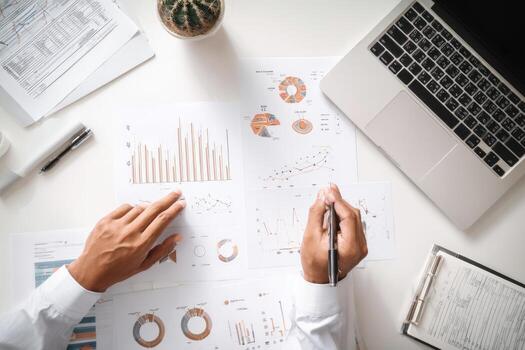 del hombre de negocios manos en escritorio con gráficos y documentos foto