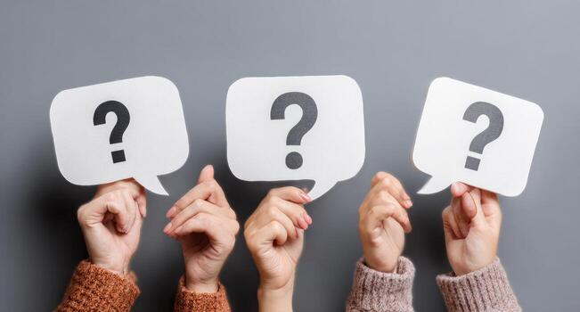 Hands holding question mark speech bubbles on gray background photo